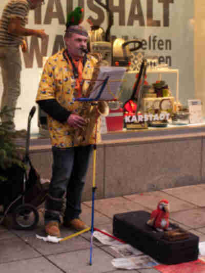 Yes, that's a man playing sax with a parrot on his head